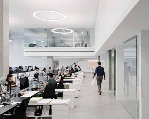 Wide angle candid view of the Henriquez Partners Architects office with a person walking away from the camera