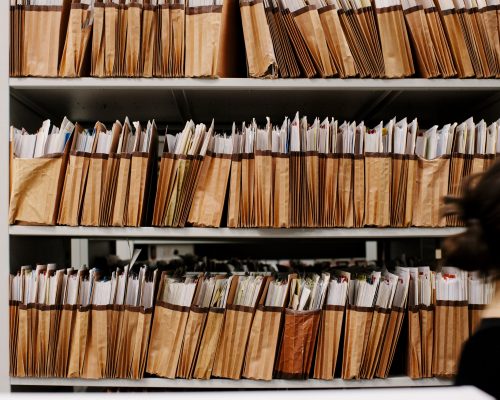 Woman walking past a shelf full of files