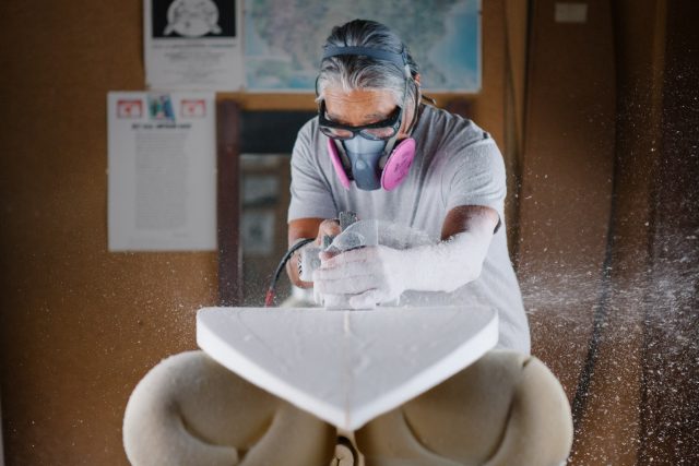 Medium photo of asian man crafting a surfboard in his workshop